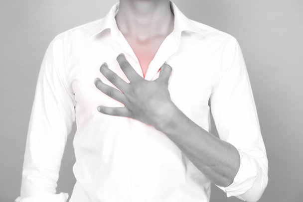 Asian man holding his chest due to a heart attack - Фото, изображение