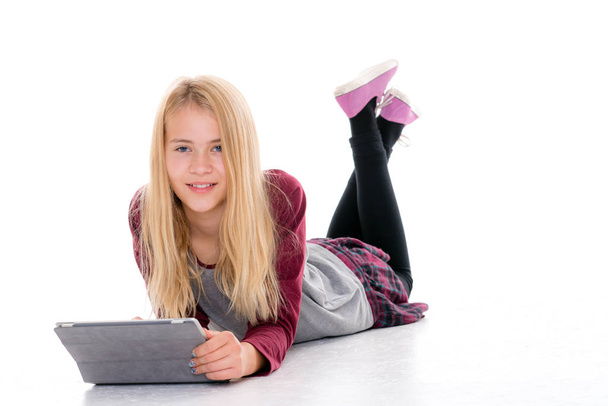 mooi blond meisje met tablet pc liggend op de vloer - Foto, afbeelding