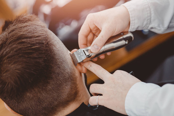 Peluquería corta hombres de pelo en la peluquería. Peluquero haciendo la barba correcta recorte máquina de afeitar eléctrica
 - Foto, Imagen