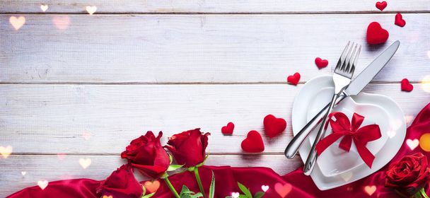 День Святого Валентина Вечеря Романтичний стіл Налаштування з подарунком і трояндами
 - Фото, зображення
