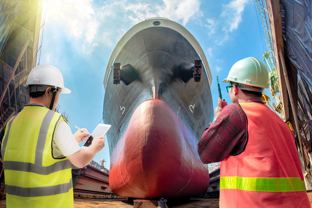 inspector, surveyor, port control or engineering and supervisor in review of the condition of the commercial ship bulk head after repainting recondition in dry dock yard, report, online - Photo, Image