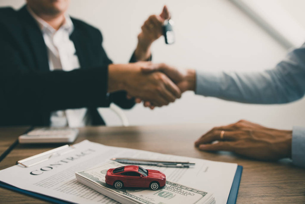 New car buyers and car salesmen are shaking hands to make agreem - Zdjęcie, obraz