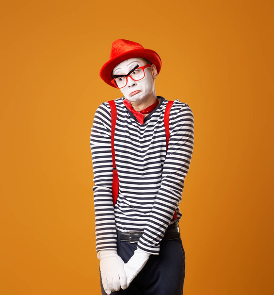 Upset mime man in red hat and vest on orange background - Foto, Imagem