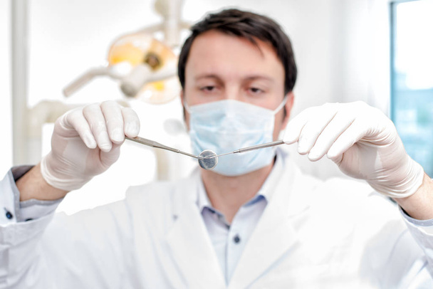 young dentist with dental mirror and dental probe - Zdjęcie, obraz