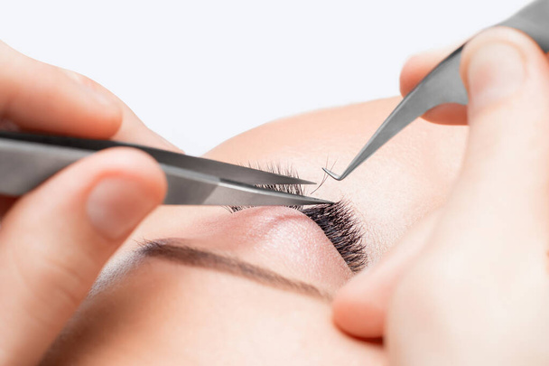 Macro photo woman with long lashes in beauty salon. Concept eyelash extension procedure - Fotó, kép