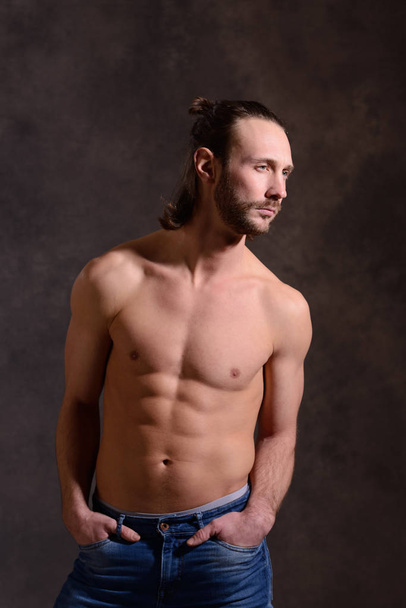young white man exercised body in front of dark background - 写真・画像