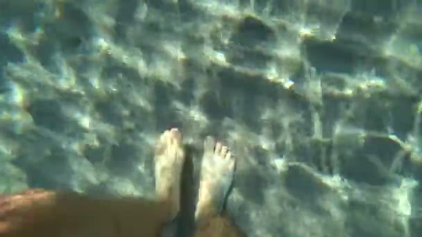 Az ember a tenger fenekén sétál. A férfi lába az aljára lép, és a homok felemelkedik. Álláspont. - Felvétel, videó