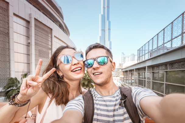 Two friends a man and a woman travel in Dubai and take a selfie photo against the background of the skyscrapers. Tourism in UAE - Foto, Imagem