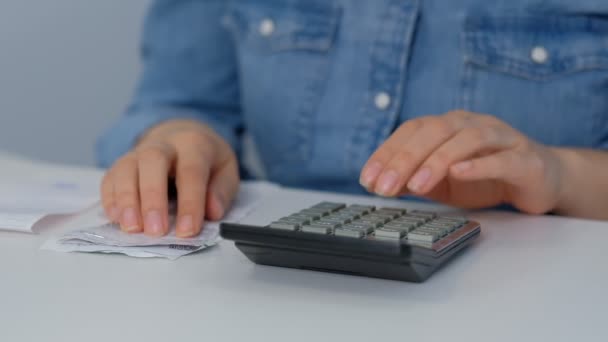 Laskentatarkastus. nuori nainen tarkistaa laskut, verot, pankkitilin saldo ja laskemalla kulut olohuoneessa kotona
 - Materiaali, video