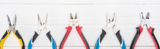 Top view of pliers on white wooden background, panoramic shot - Fotó, kép
