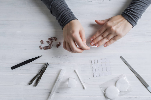 The process of putting artificial (fake) fingernail on the finger. Woman manicure. Flat lay. - Fotografie, Obrázek