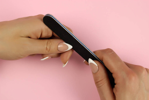 A woman makes a manicure at home with a nail file. Close up - Foto, imagen