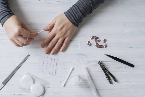 The process of putting artificial (fake) fingernail on the finger. Woman manicure. Flat lay. - Foto, afbeelding