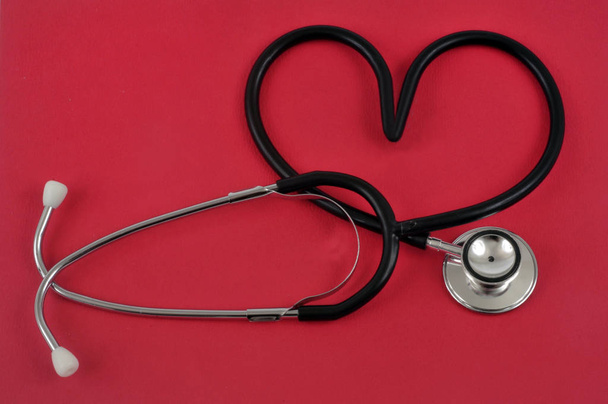 Stetoskop w kształcie serca na czerwonym tle - Zdjęcie, obraz