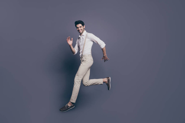 Full size photo of content elegant guy jump go copy space run moving on free time attracting girls wear good looking outfit isolated over grey color background - Foto, Imagem