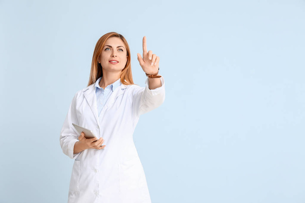 Portrait de médecin femme avec tablette montrant quelque chose sur fond de couleur
 - Photo, image