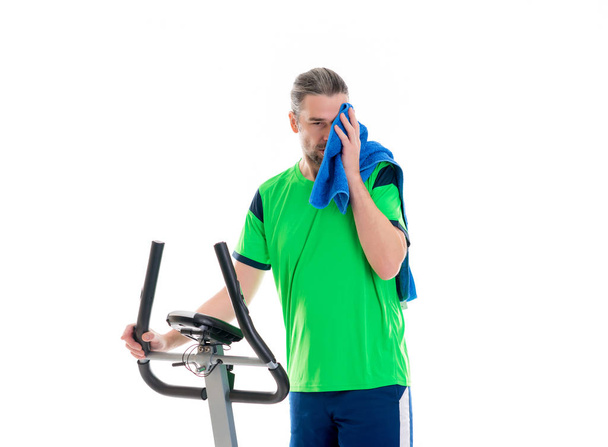 young man in green shirt train with fitness machine - Fotó, kép