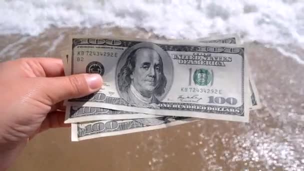 Κορίτσι που κατέχουν χρήματα νομοσχέδιο των 300 δολαρίων στο φόντο των ωκεανών της θάλασσας - Πλάνα, βίντεο