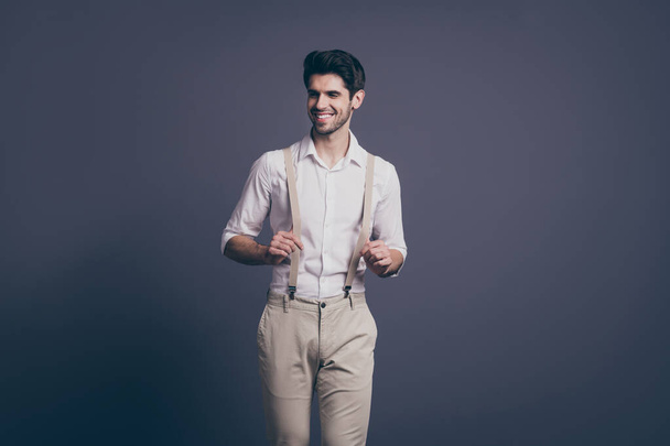 Portrait of cheerful macho man have free time walk look good touch suspenders attract girls wear classy clothing isolated over grey color background - Fotó, kép