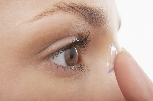 Young Woman Putting in Contact Lens - Foto, immagini