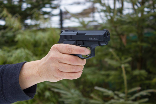 Woman shooting outdoor with a gun, selective focus - Foto, Bild