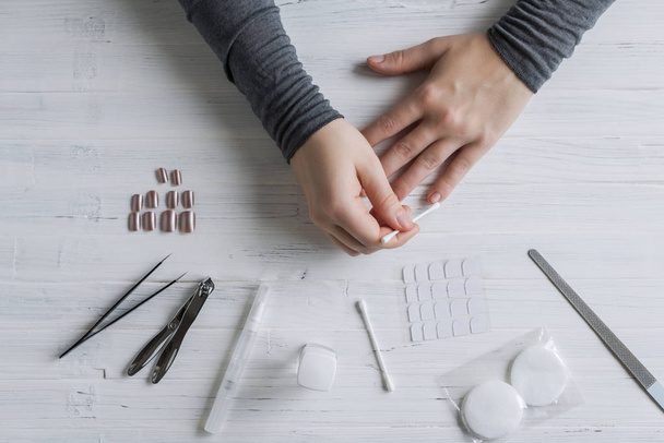 The process of putting artificial (fake) fingernail on the finger. Woman manicure. Flat lay. - Foto, Imagen