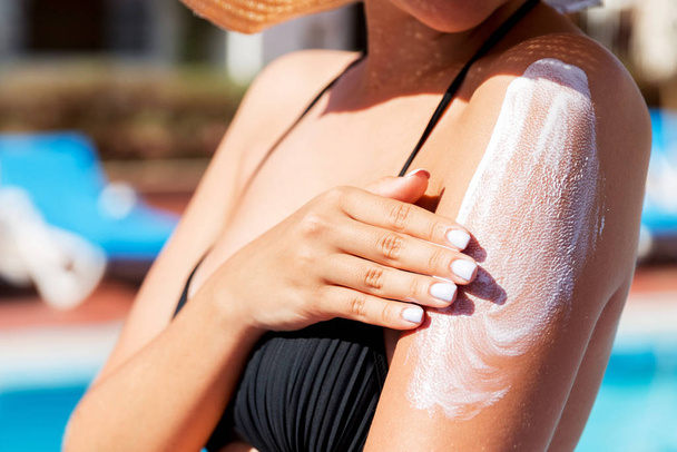 Hezká žena nanášení opalovací krém s rukama na opálené by měla - Fotografie, Obrázek
