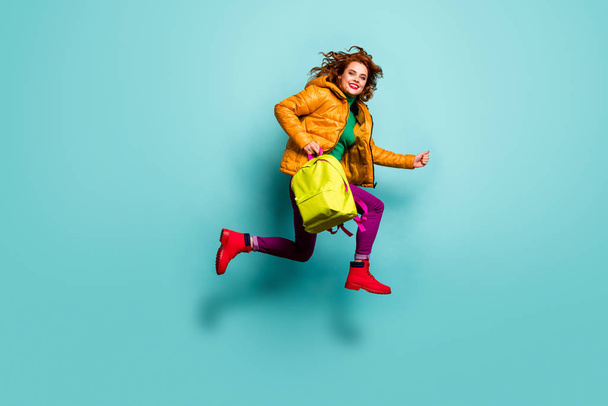 Weekend. Full body photo of funny lady jump high rush home after lessons classes carry school bag wear yellow coat scarf trousers turtleneck boots isolated teal color background - Fotografie, Obrázek