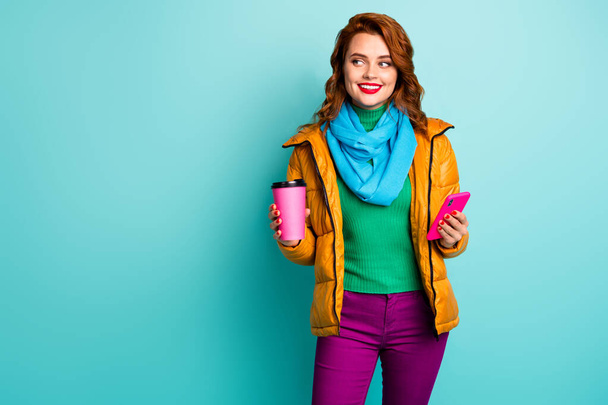Photo of funny lady hold hot coffee mug beverage smart phone telephone walk street wear casual yellow overcoat scarf trousers green jumper isolated teal color background - Valokuva, kuva