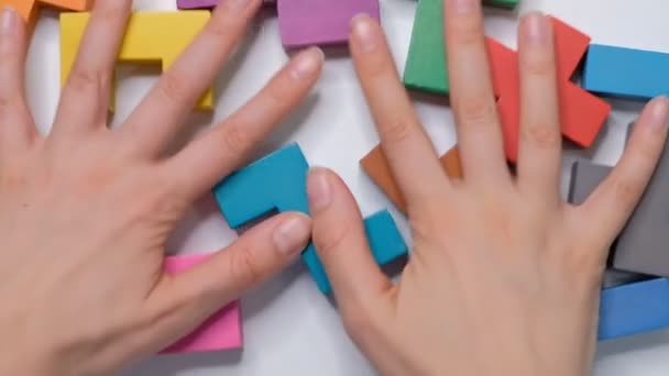 vrouwelijke handen schoon houten kubussen van een witte tafel, platte lay, frame kinderen kubussen, concept van het onderwijs aan kinderen - Video