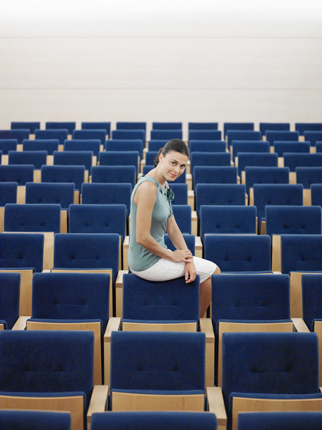Woman sitting in Auditorium - 写真・画像