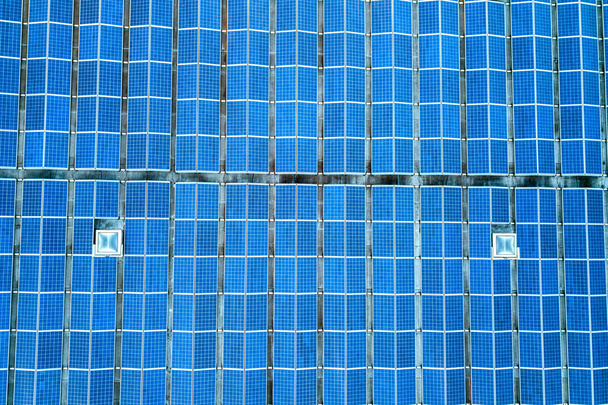 Luftaufnahme vieler Photovoltaik-Sonnenkollektoren, die von der Industrie montiert wurden - Foto, Bild