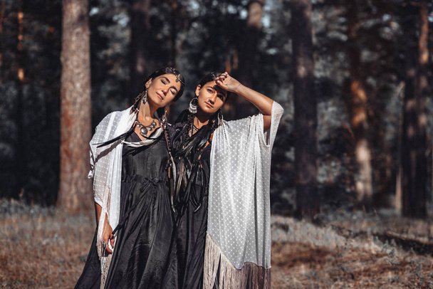 two bohemian women posing together in forest - Fotoğraf, Görsel