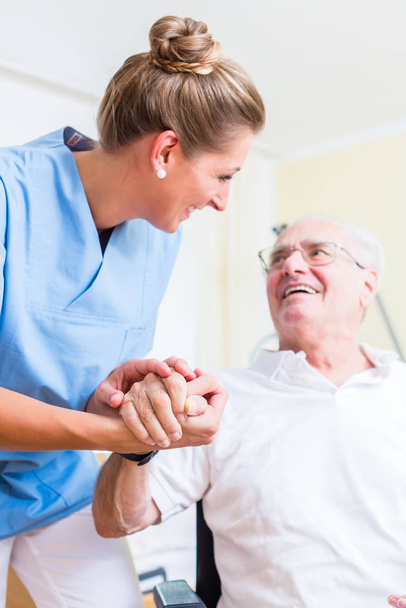 senior nurse holding hand from senior in altersheim - Foto, afbeelding