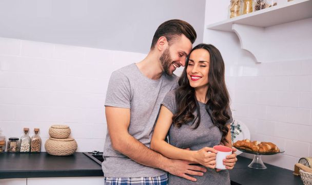 happy couple with cofffee in kitchen at home - Fotó, kép