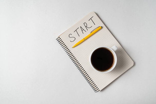 Notice START in notebook. Words handwritten. Notepad and cup of coffee on white background. - Foto, immagini