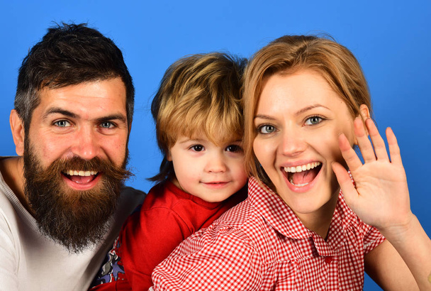 Madre, padre e hijo con caras sonrientes abrazo en azul
 - Foto, Imagen