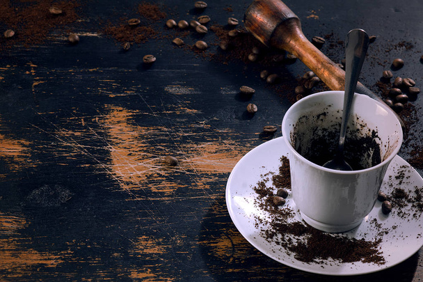 ziarna kawy i filiżanka z kawą na talerzu na tle starej deski - Zdjęcie, obraz