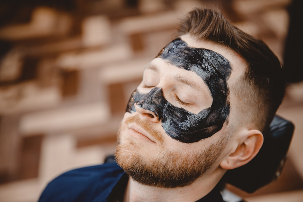 Wellness-Gesichtspflege für Männer, Entfernen der schwarzen Holzkohlemaske aus dem Nasengesicht im Friseursalon - Foto, Bild