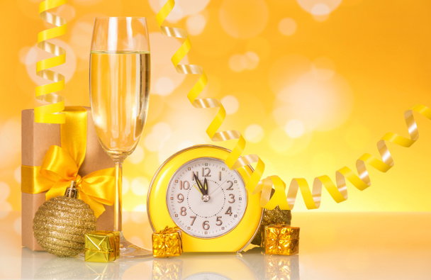 Wine glass with champagne, presents and watches on bright sparkling background - Fotoğraf, Görsel
