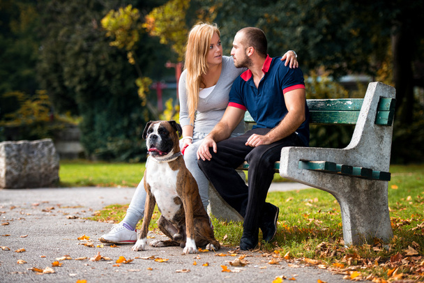 Couple Sitting Outdoors With Her Pet Dog German Boxer - Foto, imagen