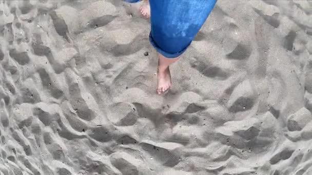 Černý stín dívky, která kráčí podél písečné pláže na břehu - Záběry, video