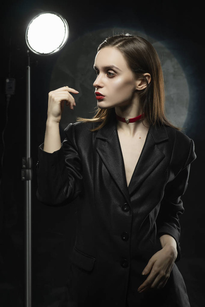 Beautiful slim girl model with red lips, wearing a black blazer, - Photo, image