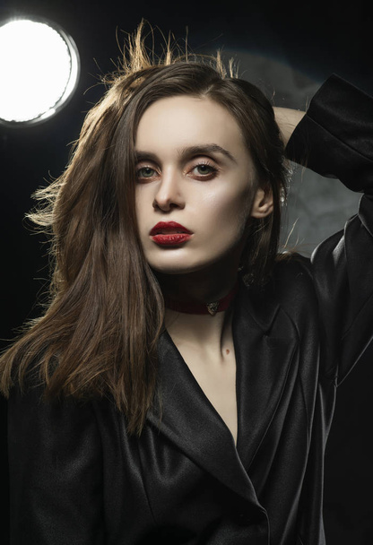 Beautiful slim girl model with red lips, wearing a black blazer, - Фото, изображение
