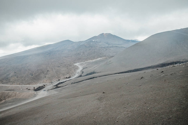 Gipfel des Vulkans Ätna, eiskalte Lava raucht, dicke Wolken - Foto, Bild