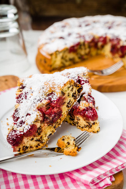 cherry cake with icing sugar on a plate - Foto, imagen