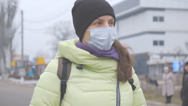 Захист від китайського коронавірусу в європейському місті. Молода жінка в громадському місці стоїть у медичній масці в Німеччині. Початок симптомів коронавірусу.. - Кадри, відео