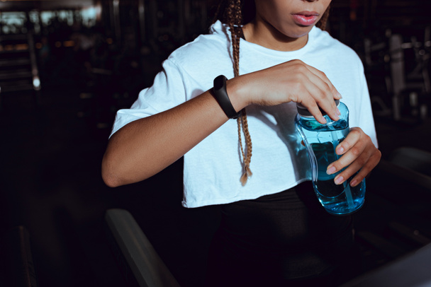 Cropped view of african american woman holding sports bottle of water - Fotografie, Obrázek