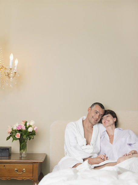 Smiling couple relaxing in bed - Foto, immagini