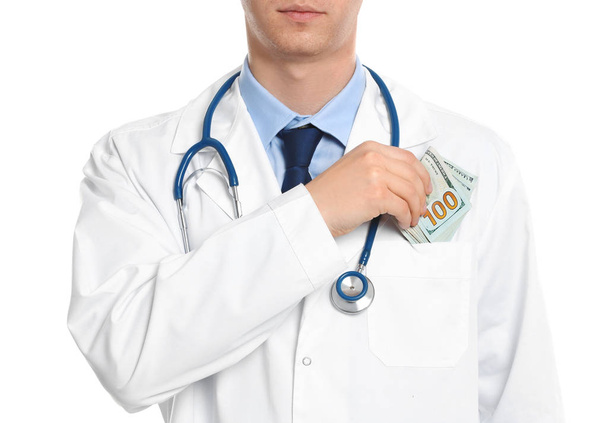 Doctor putting bribe into pocket on white background, closeup. C - Photo, image